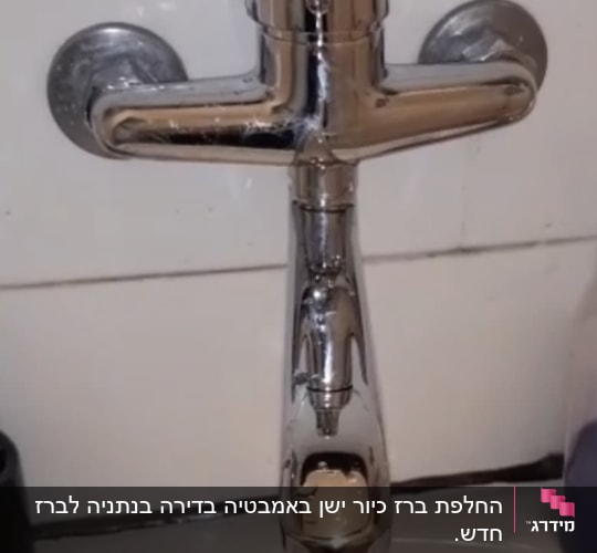 ברז מים מותקן על קיר בחדר אמבטיה